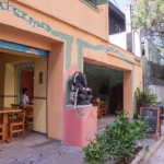 Fachada do Gopala Restaurante Indiano em São Paulo, com entrada decorada em estilo indiano e vegetação ao redor.